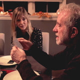Man picking up Question Card at a table in front of a woman