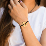 Woman wearing bracelet with a Token that says "Impact"