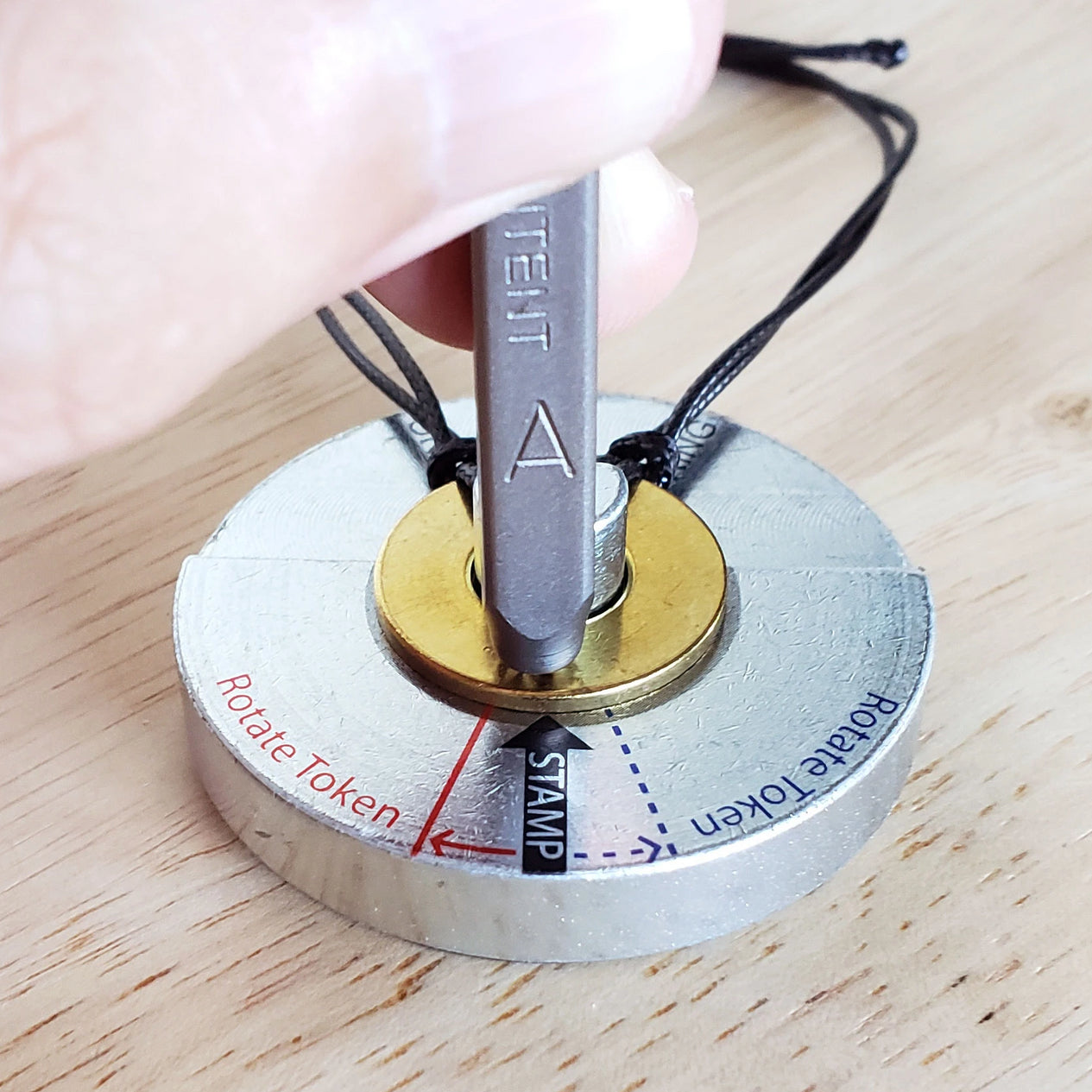 Person aligning their letter metal stamp on their bracelet token on the MyIntent Metal Stamping Base