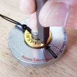 Person stamping the word INSPIRE on their classic bracelet which is placed on a metal stamping base