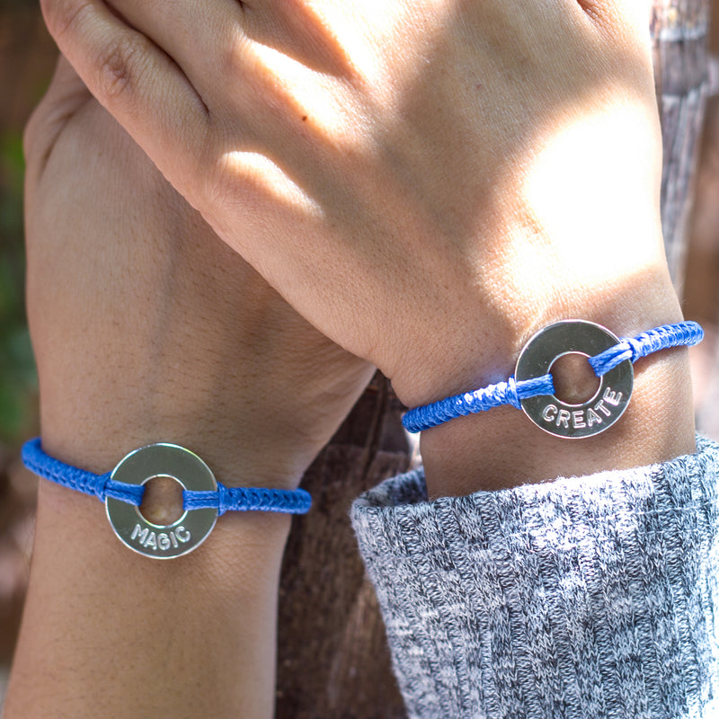 Couple with matching Custom Round Bracelet Silver Token Blue String with words MAGIC & CREATE