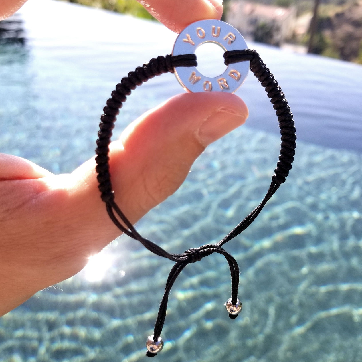 Person holding their MyIntent Custom Round Bracelet Silver Token Black String