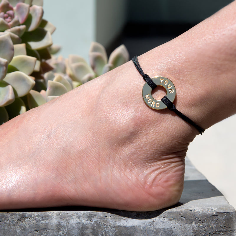 A girl showing her MyIntent Custom Twist Anklet Black String with Gold Token 