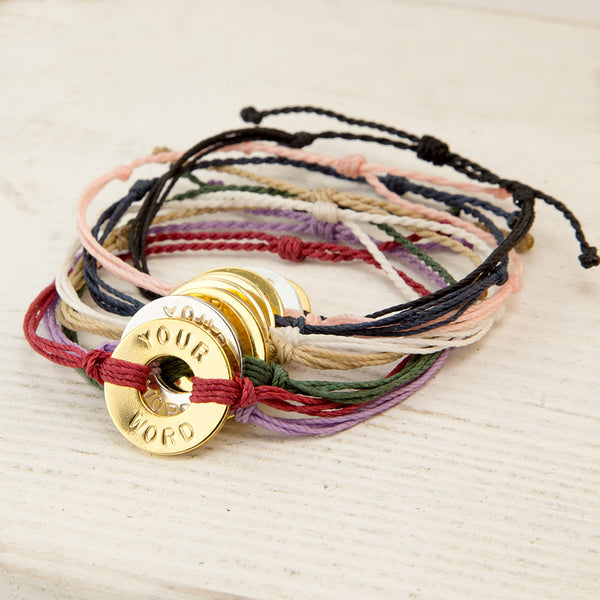 Pack of multicolor tokens on multicolored strand bracelets that say "Your Word" 