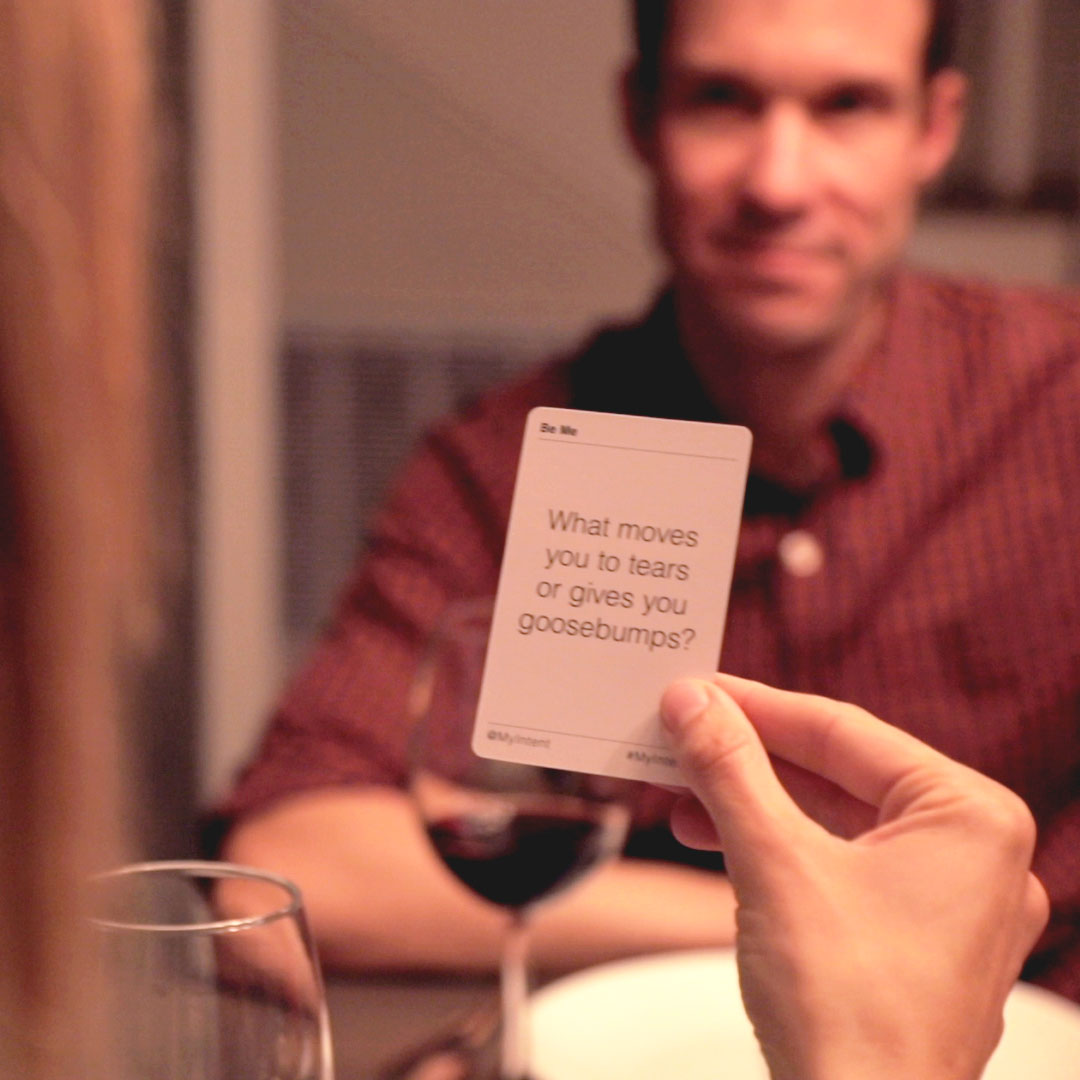 A woman holding a MyIntent Question card reading it to her friend