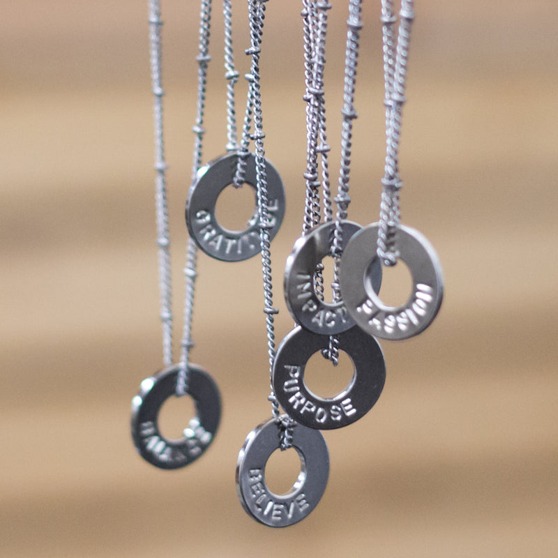A set of hanging MyIntent Group Order Custom Bead Necklaces in Nickel with a variety of words