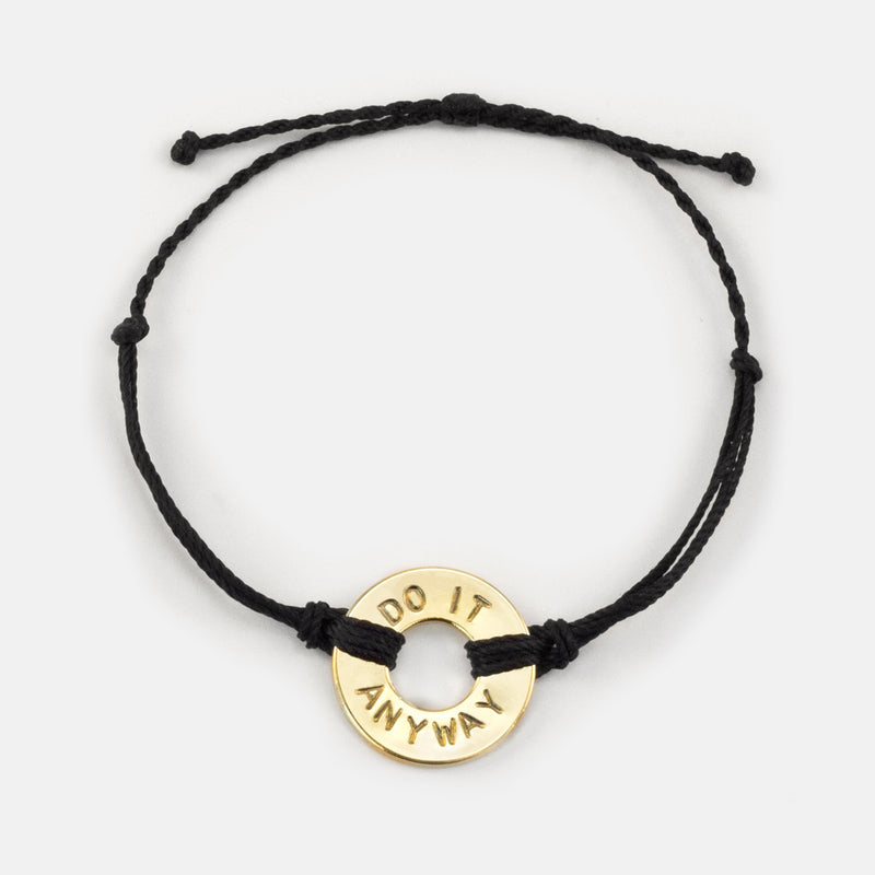 Mel Robbins' signature Twist Bracelet Black String Gold Token with the words DO IT ANYWAY