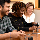 A group of people making bracelets by using their MyIntent Maker Kits 