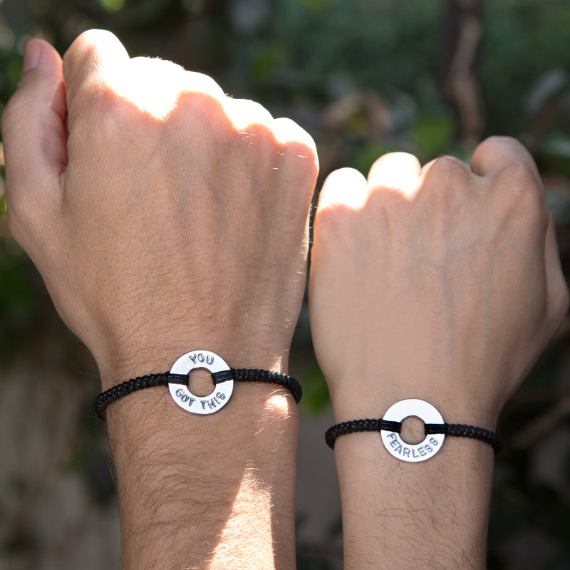 A couple matching Custom Round Bracelet Silver Token Black String with words YOU GOT THIS & FEARLESS