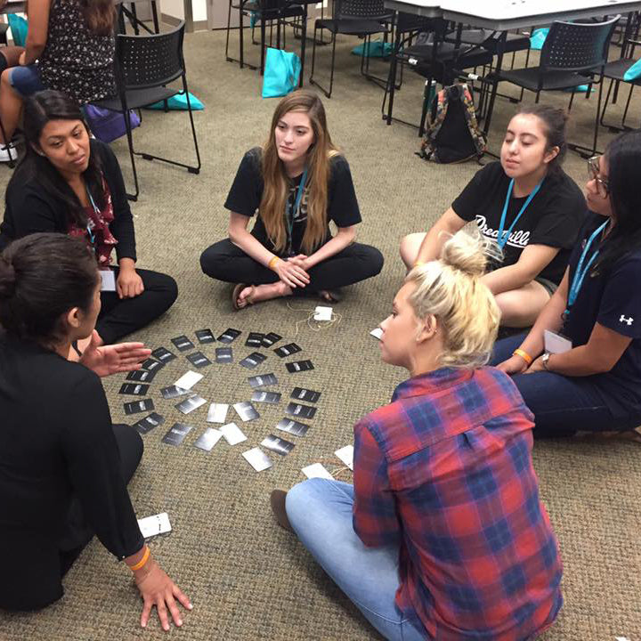 A group of individuals reading and sharing their answers after reading from the questin cards